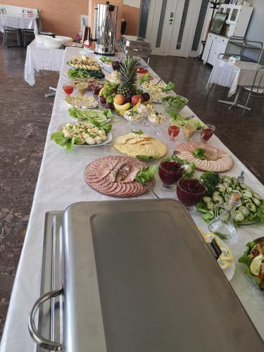 un lungo tavolo con molti piatti di cibo sopra di OWR Kamyczek a Sarbinowo
