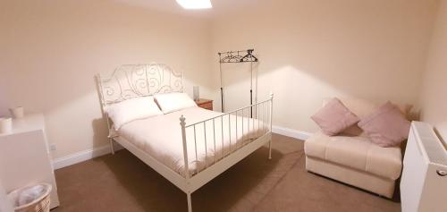 a bedroom with a white bed and a couch at Grace Apartments - Living Waters 2 in Ashford