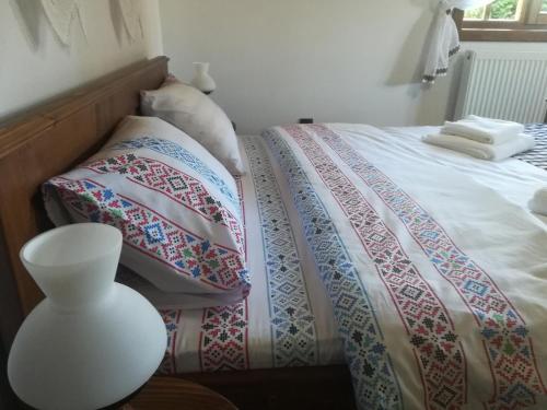 a bed with two pillows and a table with a lamp at Casa din Susani in Călineşti
