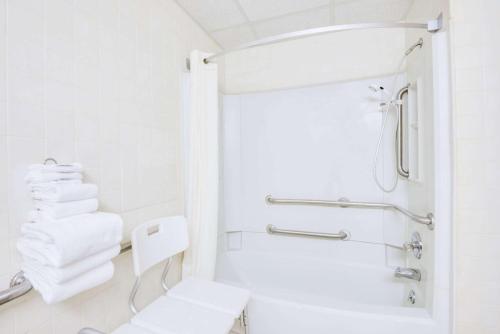 y baño blanco con aseo y ducha. en Super 8 by Wyndham Port Clinton, en Port Clinton