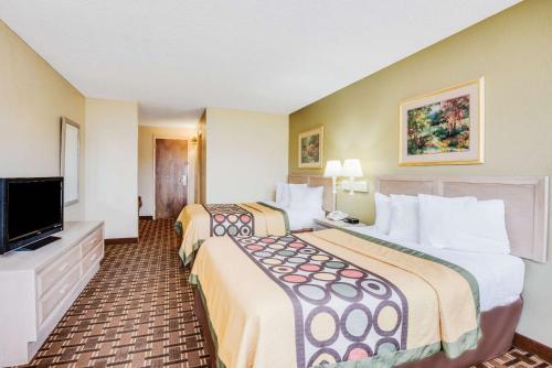 a hotel room with two beds and a television at Super 8 by Wyndham Port Clinton in Port Clinton