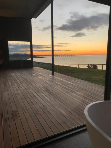 a bathroom with a view of the ocean from a deck at The Cove Tasmania in Devonport