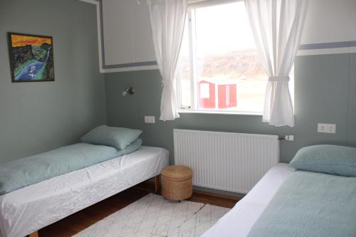 A bed or beds in a room at Stóri-Bakki Guesthouse-with hot tub