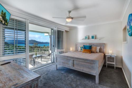 a bedroom with a bed and a view of the ocean at Poinciana Lodge - 2 bedroom - on Hamilton Island by HIHA in Hamilton Island