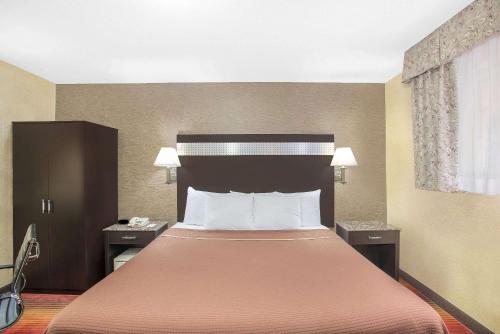 een hotelkamer met een bed met een oranje sprei bij Howard Johnson by Wyndham North Bergen in North Bergen