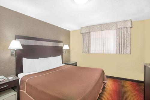 a hotel room with a bed and a window at Howard Johnson by Wyndham North Bergen in North Bergen