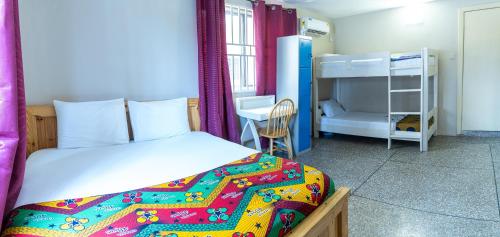 Brannic Lodge في آكرا: غرفة نوم مع سرير وسرير بطابقين