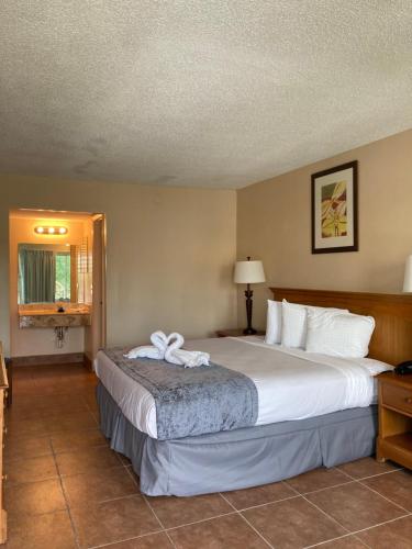 a hotel room with a large bed with a bow on it at Altamonte Springs Hotel and Suites in Orlando