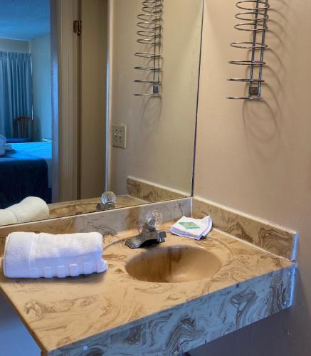 a bathroom counter with a sink and a mirror at Altamonte Springs Hotel and Suites in Orlando