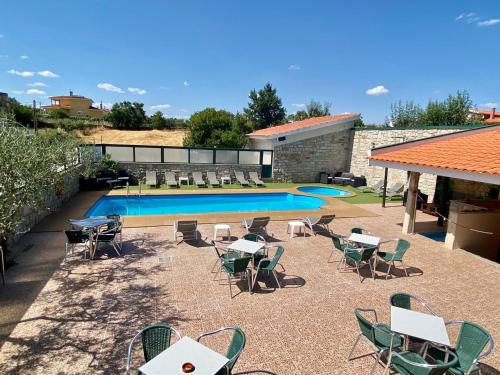 eine Terrasse mit Tischen und Stühlen sowie einem Pool in der Unterkunft Hotel O Encontro in Sendim