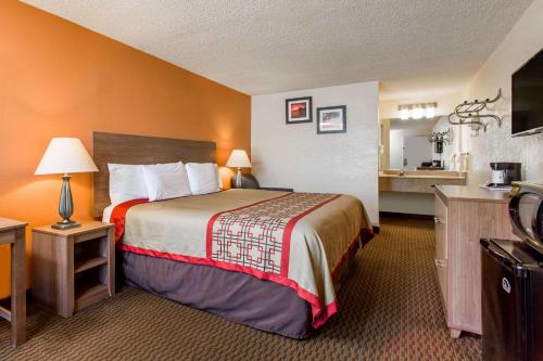 a hotel room with a bed and a kitchen at Days Inn by Wyndham Norfolk Airport in Norfolk