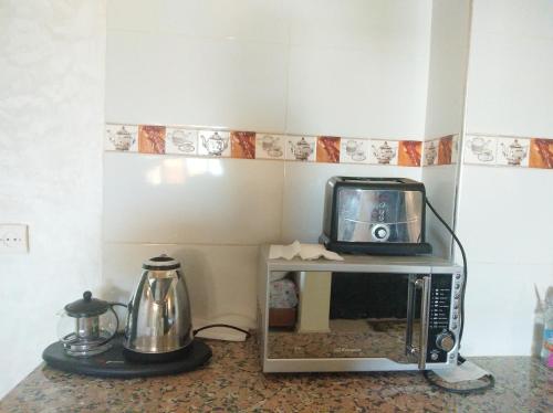 a microwave sitting on top of a counter with a kettle at Hôtel Marrakech in Tangier