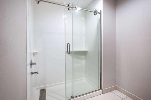 a shower with a glass door in a bathroom at Baymont by Wyndham Traverse City in Traverse City