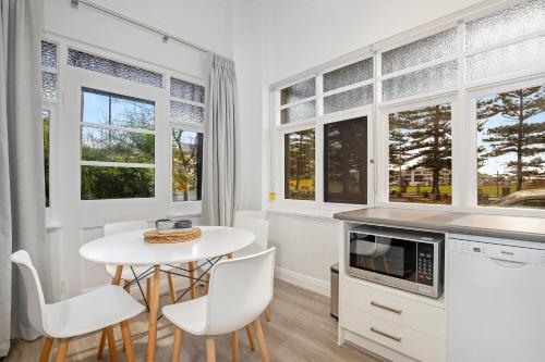 a kitchen with a table and a microwave at Bayview Apartments in Adelaide