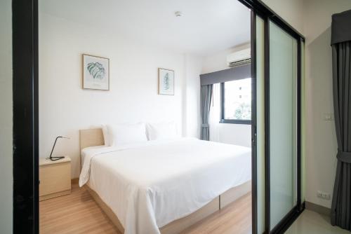 a bedroom with a white bed and a window at KOS Hotel Suvarnabhumi Airport -SHA Extra Plus in Min Buri