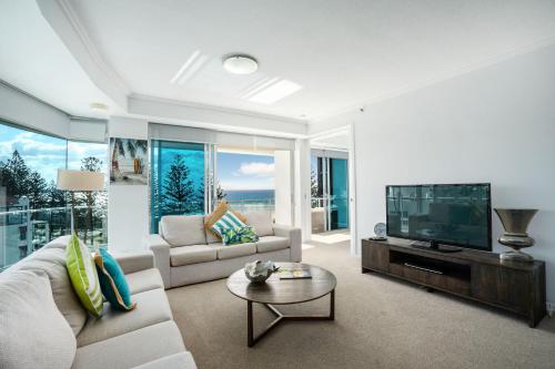 a living room with a couch and a flat screen tv at Reflections Tower Two in Gold Coast