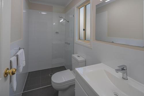 a bathroom with a toilet, sink, and bathtub at Ingenia Holidays One Mile Beach in One Mile