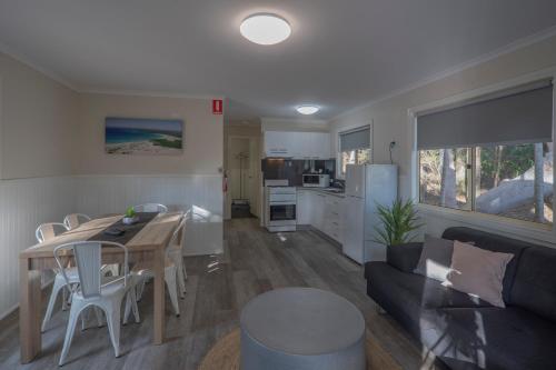 a kitchen and living room with a table and a couch at Ingenia Holidays One Mile Beach in One Mile