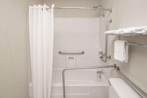 a bathroom with a shower with a white shower curtain at Super 8 by Wyndham Shreveport in Shreveport