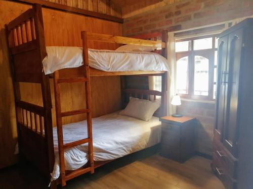 מיטה או מיטות קומותיים בחדר ב-El Encanto del Taita Imbabura
