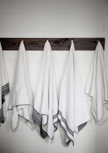 a group of white towels hanging on a wall at Cottage At 31 in Bundanoon