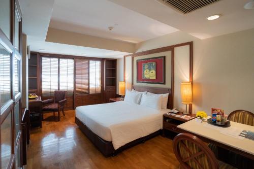 a hotel room with a bed and a desk and a desk at Centre Point Sukhumvit Thong-Lo in Bangkok