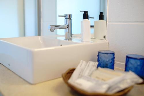 a bathroom with a sink and a mirror at 413 Hamahiga Hotel＆Cafe in Uruma