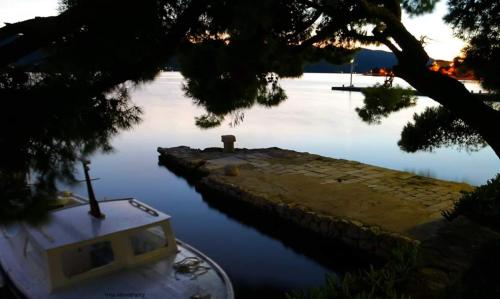 un barco está estacionado junto a un muelle en el agua en Apartments Petković, en Kućište