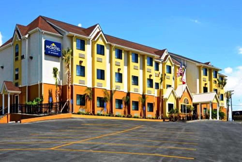 un gran edificio amarillo con aparcamiento en Microtel Inn & Suites by Wyndham New Braunfels I-35 en New Braunfels