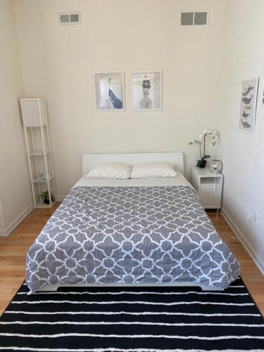 Schlafzimmer mit einem Bett mit einer blauen und weißen Bettdecke in der Unterkunft Cozy bedrooms at University City in Philadelphia in Philadelphia