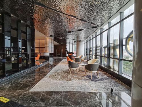 a lobby with chairs and a table in a building at Paco Hotel Jinfeng Metro Guangzhou-Free Shuttle Bus For Canton Fair-Self-service laundry in Guangzhou