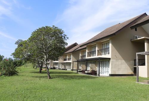 an exterior view of a building with a tree at Grand Luley Manado in Manado