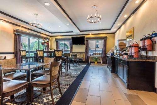 a restaurant with a bar and tables and chairs at Days Inn & Suites by Wyndham Mineral Wells in Mineral Wells