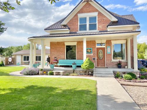 a brick house with a blue bench in the front yard at The Panguitch House in Panguitch