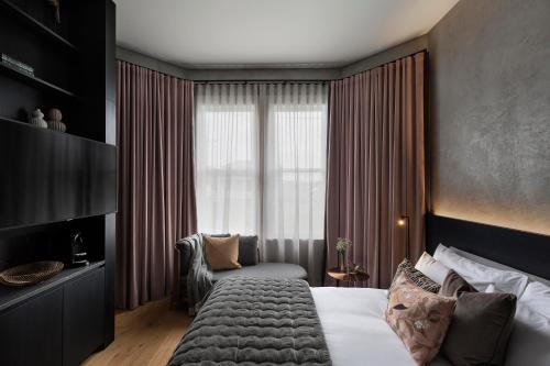 a bedroom with a large bed and a window at Hotel Fitzroy curated by Fable in Auckland