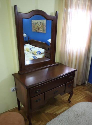 a wooden dresser with a mirror on top of it at Hotel Laguna in Podgorica