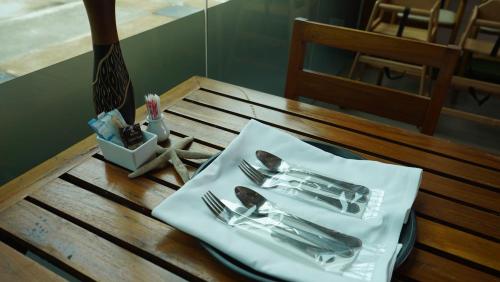 a table with cutlery on top of a wooden table at Sugar Palm Grand Hillside - SHA Plus in Kata Beach
