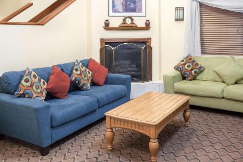 a living room with a blue couch and a coffee table at Baymont by Wyndham Fort Wayne in Fort Wayne