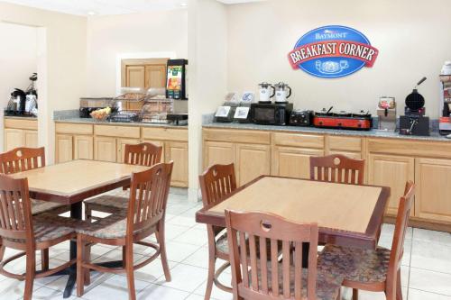 a restaurant with a table and chairs in a kitchen at Baymont by Wyndham Fort Wayne in Fort Wayne