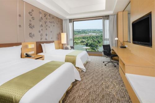 um quarto de hotel com duas camas e uma televisão de ecrã plano em Holiday Inn Nanyang, an IHG Hotel em Nanyang