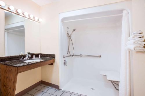 een badkamer met een wastafel en een spiegel bij Baymont by Wyndham Forest City in Forest City
