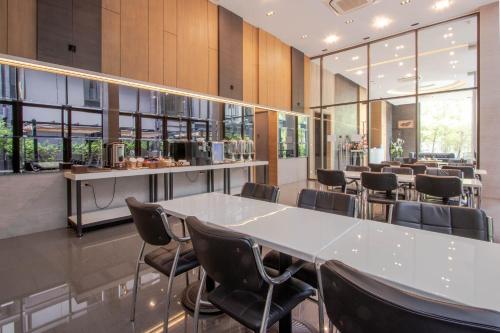 a restaurant with a large white table and chairs at Kepler Residence Bangkok in Bangkok