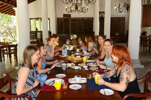 Un grupo de personas sentadas alrededor de una mesa comiendo en The Heritage Hotel Galle Fort, en Galle