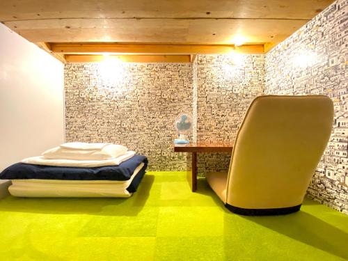 um quarto com uma cama, uma mesa e uma cadeira em Guest House MARUYA em Atami