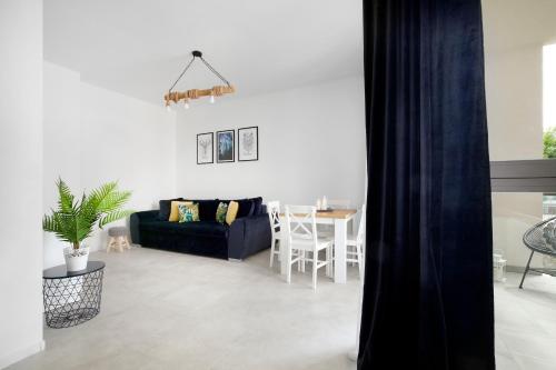a living room with a blue couch and a table at Elite Apartments Garden Gates Premium in Gdańsk