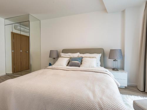 um quarto com uma cama grande e um espelho grande em VacationClub – Seaside Park Apartament 316 em Colberga