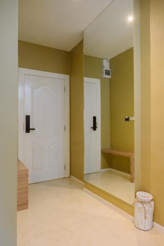 a room with two white doors and yellow walls at The Cape Hotel in Udon Thani