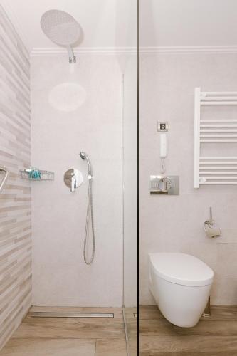 a bathroom with a shower with a toilet and a sink at Akti Taygetos - Conference Resort in Kalamata