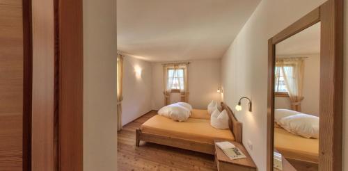 1 Schlafzimmer mit 2 Betten und einem Spiegel in der Unterkunft Naturresidenz Theistadl in Ulten