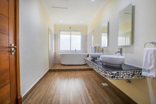 a bathroom with two sinks and a bath tub at Lake Elementaita Mountain Lodge in Nakuru